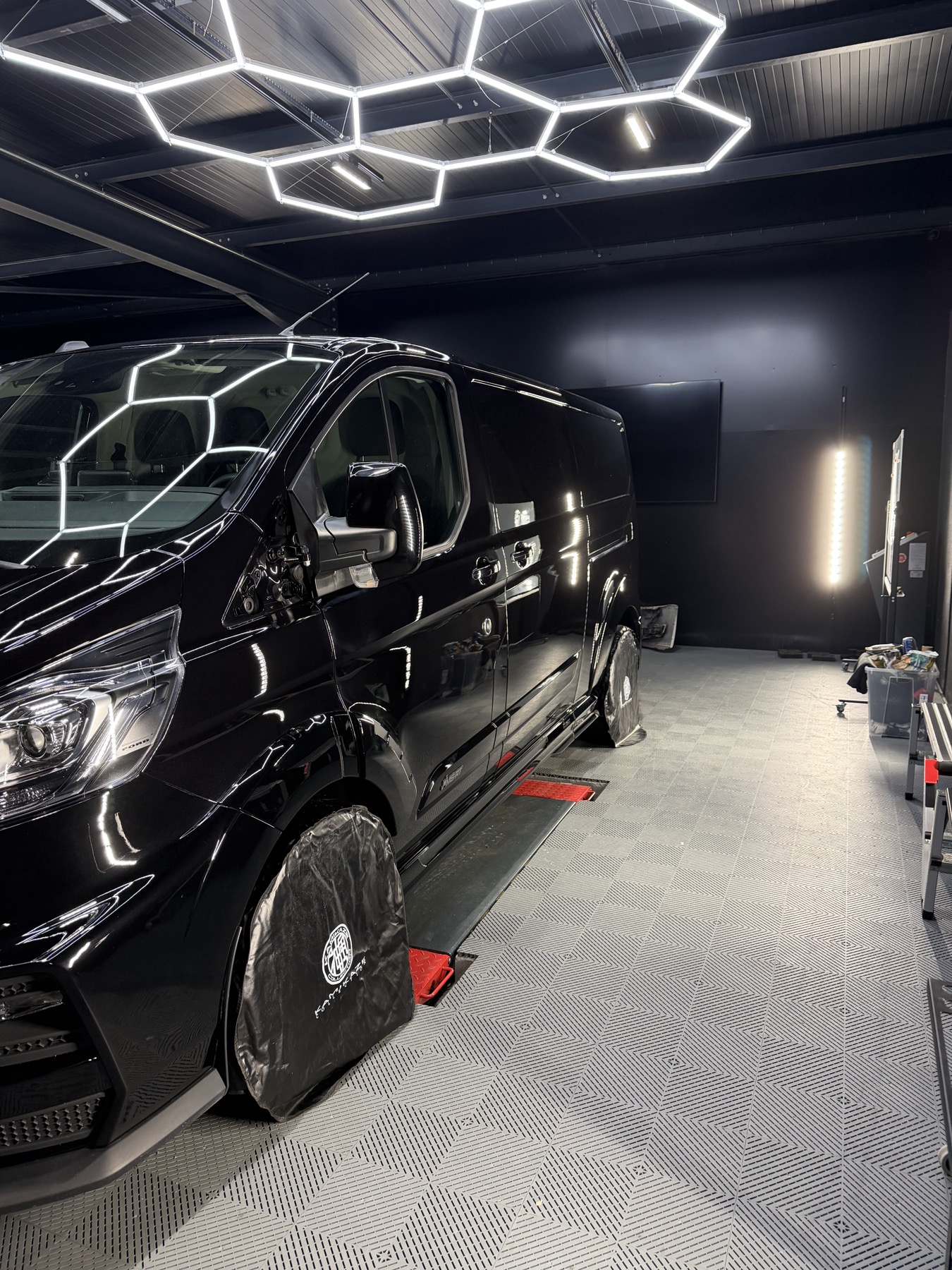 Véhicule noir en cours de préparation dans l’atelier de detailing