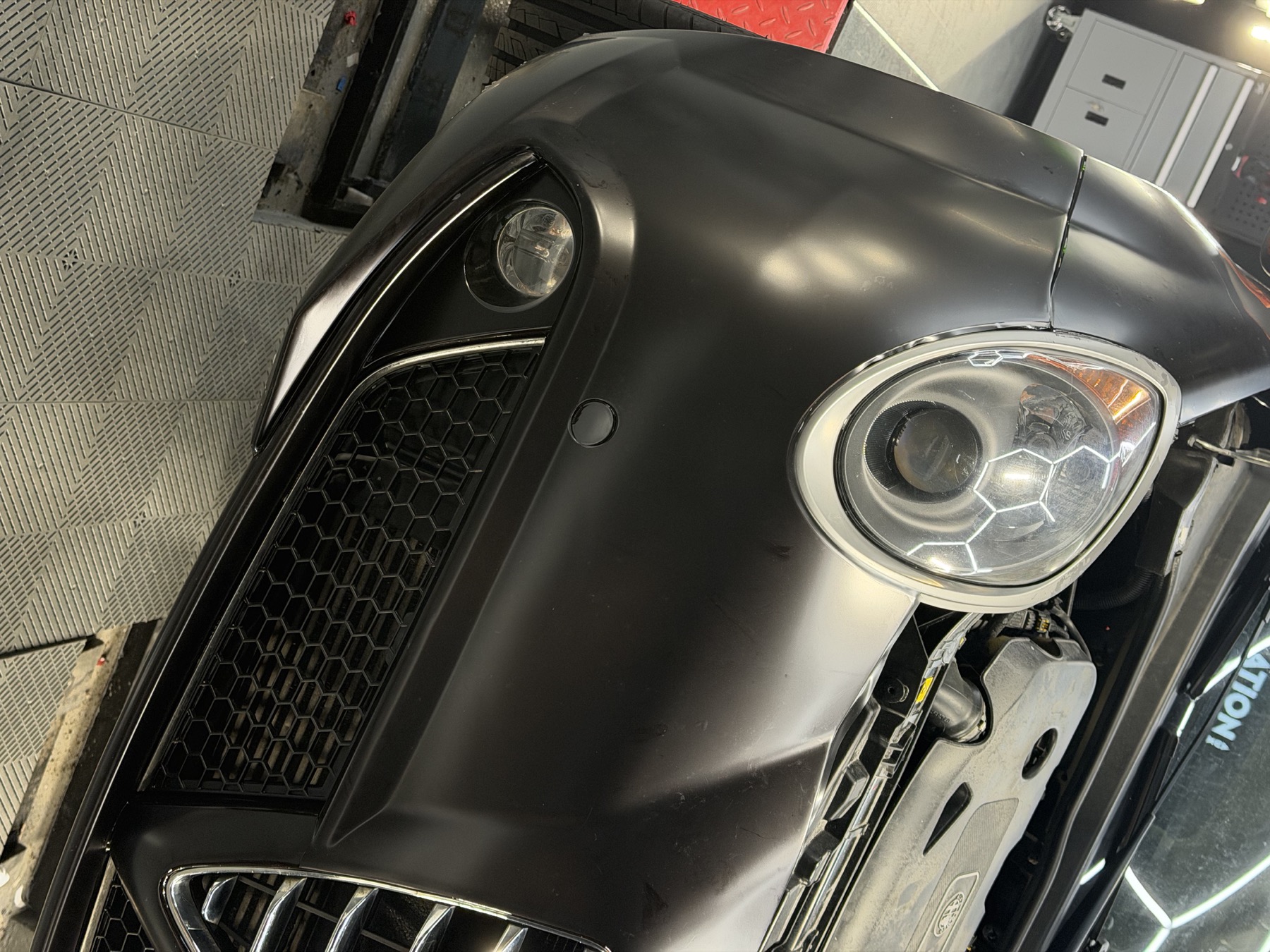 Pose d’un film de protection PPF sur le pare-chocs d’une Alfa Romeo noire